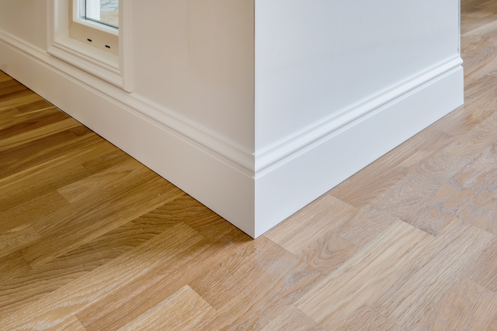 Detail of corner flooring with intricate crown molding and plinth.